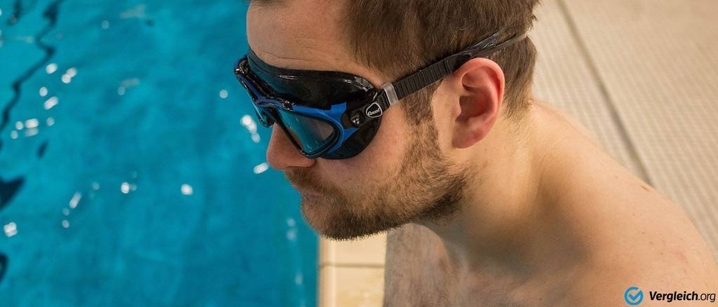 Schwimmbrille im Test: Mann mit Schwimmmaske steht am Beckenrand; im Hintergrund Wasser