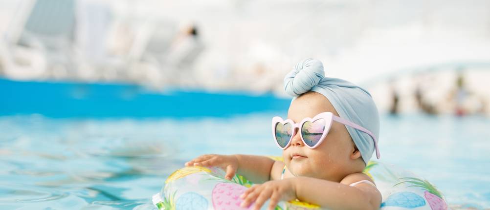 Schwimmhilfe-ab-1-Jahr-Test: Ein Kind sitzt in einem Schwimmreifen und trägt dabei eine Sonnenbrille.