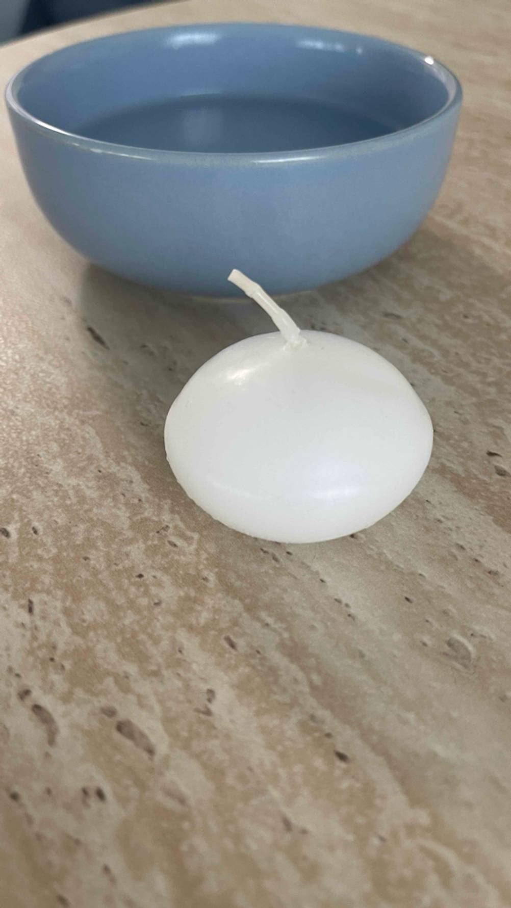 Schwimmkerzen-Test: Eine Kerze liegt auf einer marmorierten Fläche.