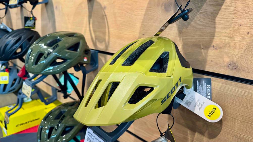 An einer Befestigung an der Wand befindet sich der getestete Scott-Fahrradhelm neben anderen Produkten.