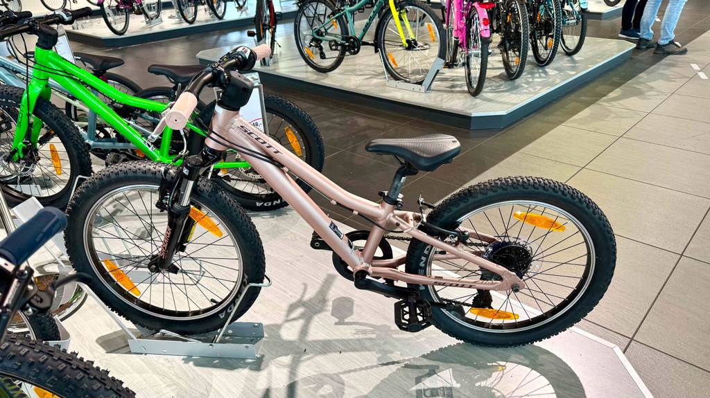 Das rosafarbene getestete Mountainbike 20 Zoll steht von oben betrachtet auf einem Ausstellungspodest.
