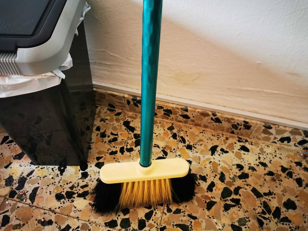 Nahansicht eines Besenstiels, der in einem Besen verschraubt ist.
