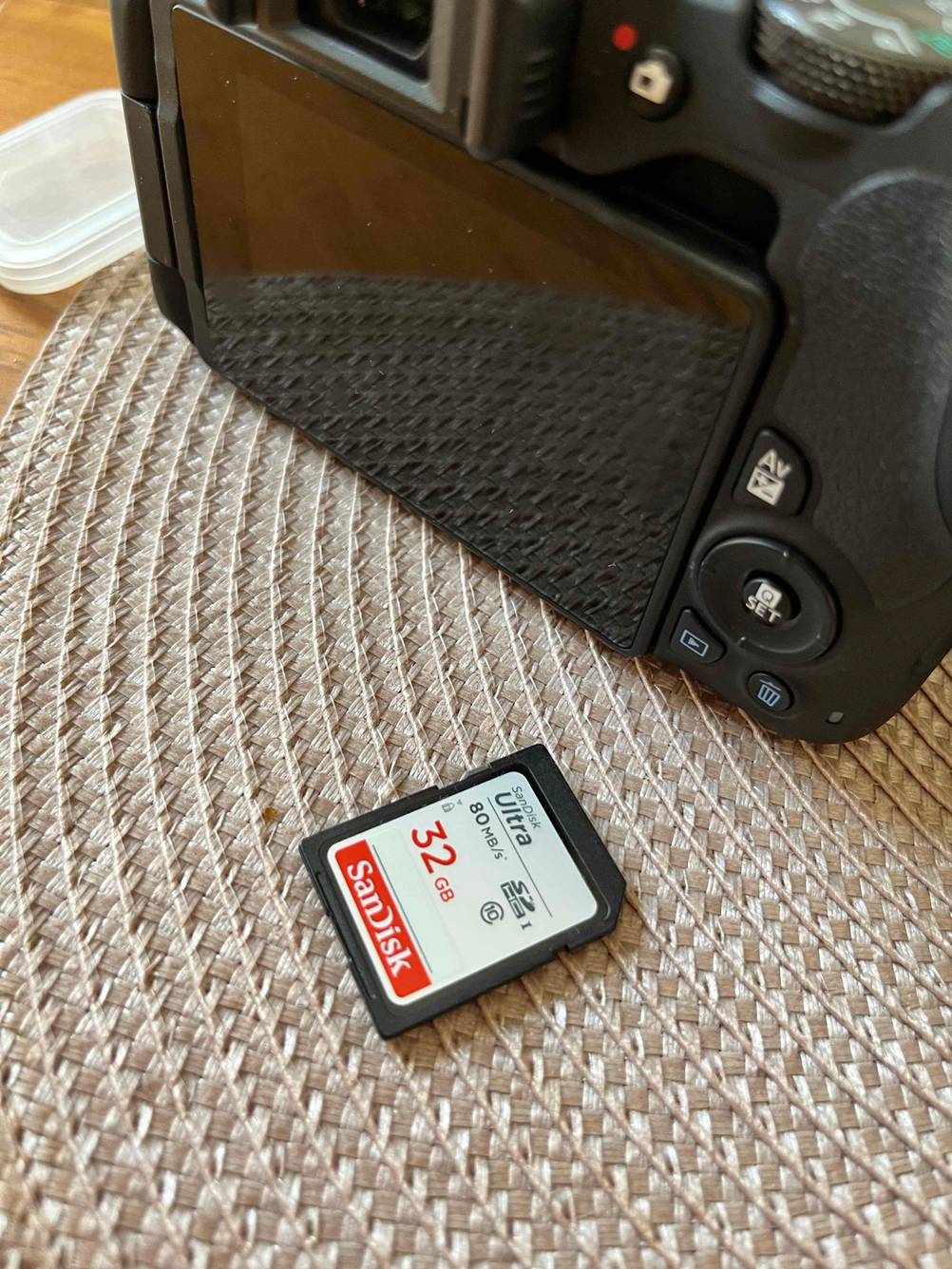 Vor einem Kameragehäuse von hinten liegt eine getestete SD-Karte.