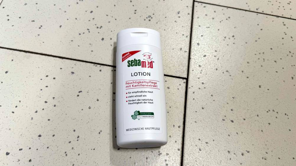 Eine Flasche der getesteten Sebamed-Bodylotion von oben auf einem Fließenboden.