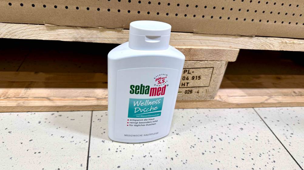 Sebamed-Duschgel im Test: Eine Flasche vor einer Holzpalette auf dem Boden.