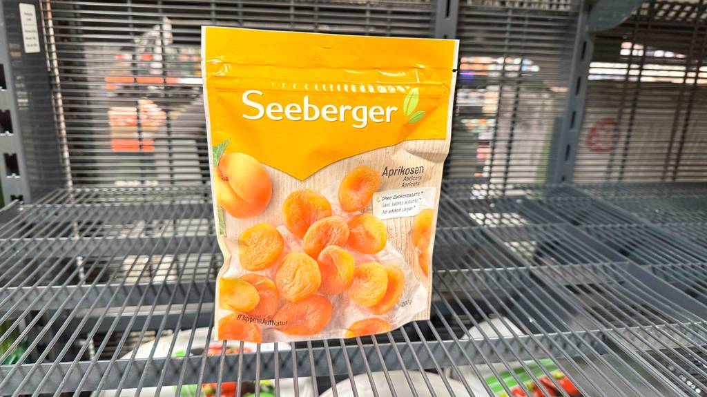 Eine Packung Seeberger-Trockenfrüchte steht zum testen in einem Gitterregal.