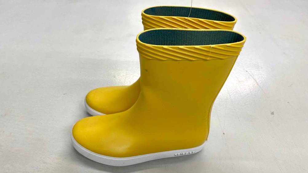 Ein Paar Segelstiefel im Test von der Seite auf einem Betonboden.