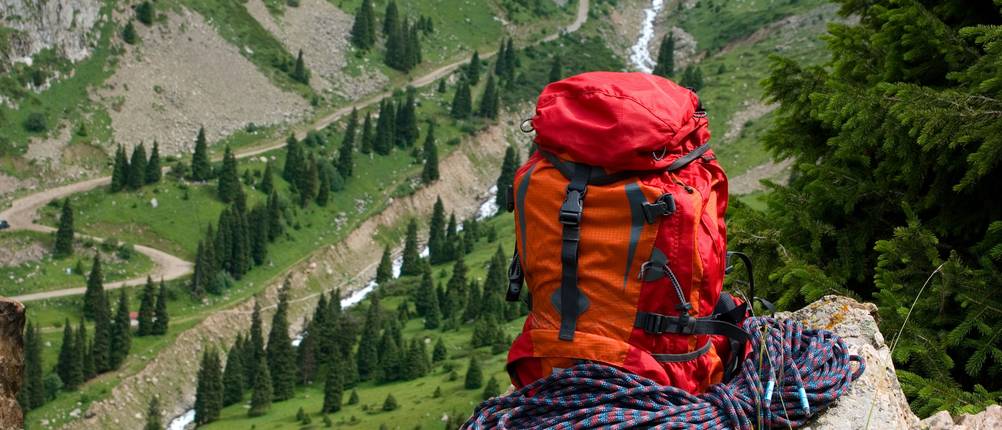 Seilsack-Test: roter Rucksack steht auf einem Fels im Gebirge. Davor liegt ein Kletterseil.