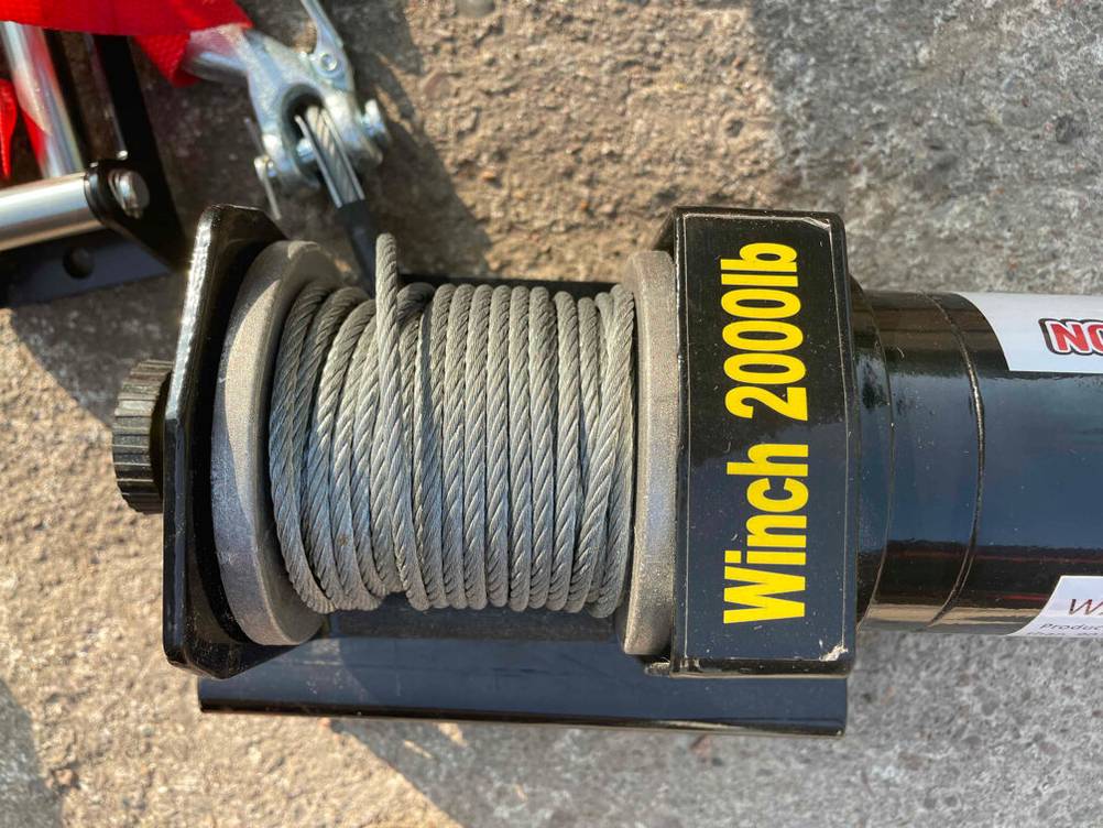 Eine getestete Seilwinde 12 V von oben auf einem Teerboden.