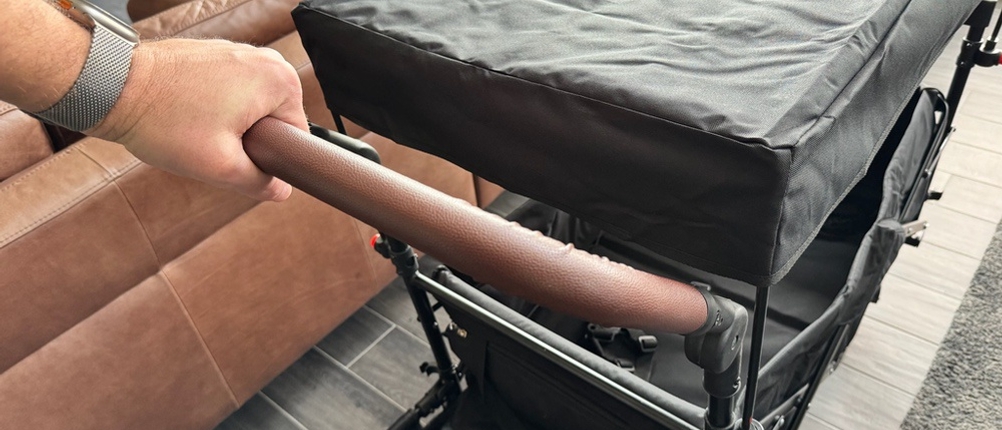 Eine Hand hält den Griff des Sekey-Bollerwagens fest.