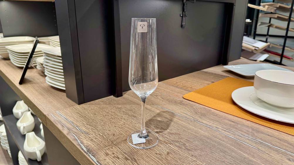 Sektgläser getestet: Ein Glas steht auf einem Regal im Hintergrund Geschirr.
