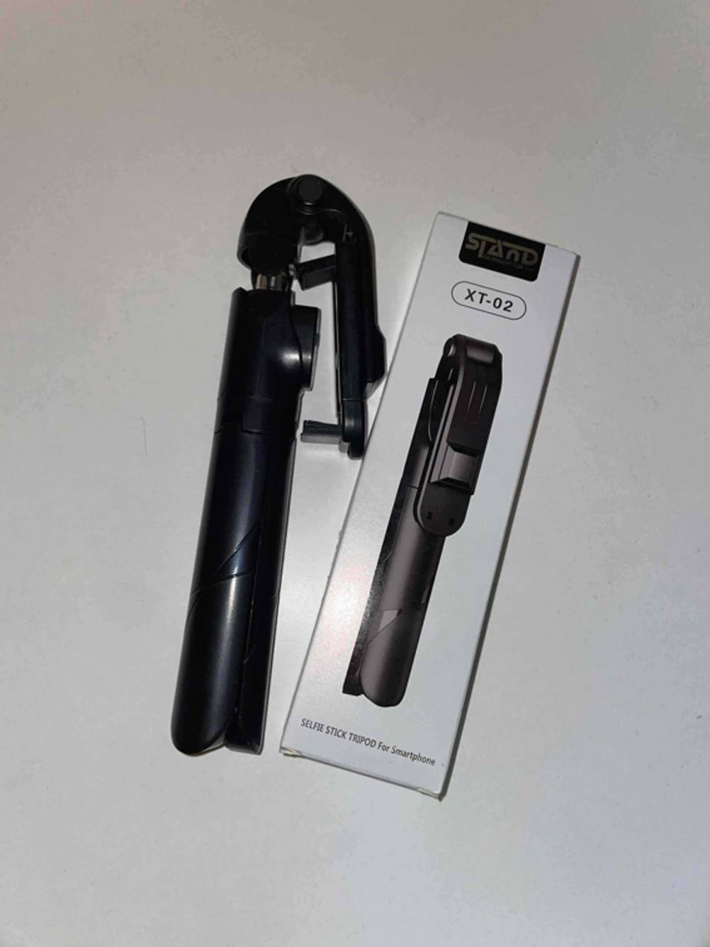 Im Test: Ein Selfie-Stick neben seiner Originalverpackung auf einer hellen Fläche.