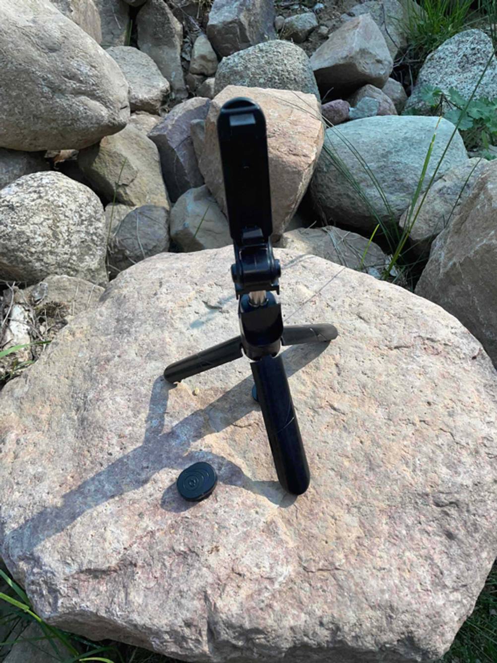 Selfie-Stick getestet: Ein Stick mit Stativ steht auf einem Stein.