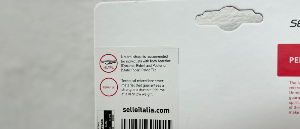 Auf der Verpackung des Selle Italia SLR Super Flow sind Informationen zur Sattelform und zum Material abgedruckt. Begriffe wie „Neutral“ und „Fibra-Tek“ sind zu erkennen.