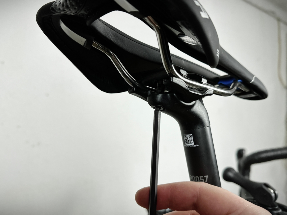 Der Selle Italia SLR Super Flow wird mithilfe eines Inbusschlüssels an der Sattelstütze montiert. Eine Hand hält das Werkzeug im unteren Bereich des Bildes.