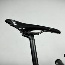 Der Selle Italia SLR Super Flow ist seitlich an einem Rennrad montiert. Der Hintergrund ist neutral und hebt das Sattelprofil hervor.
