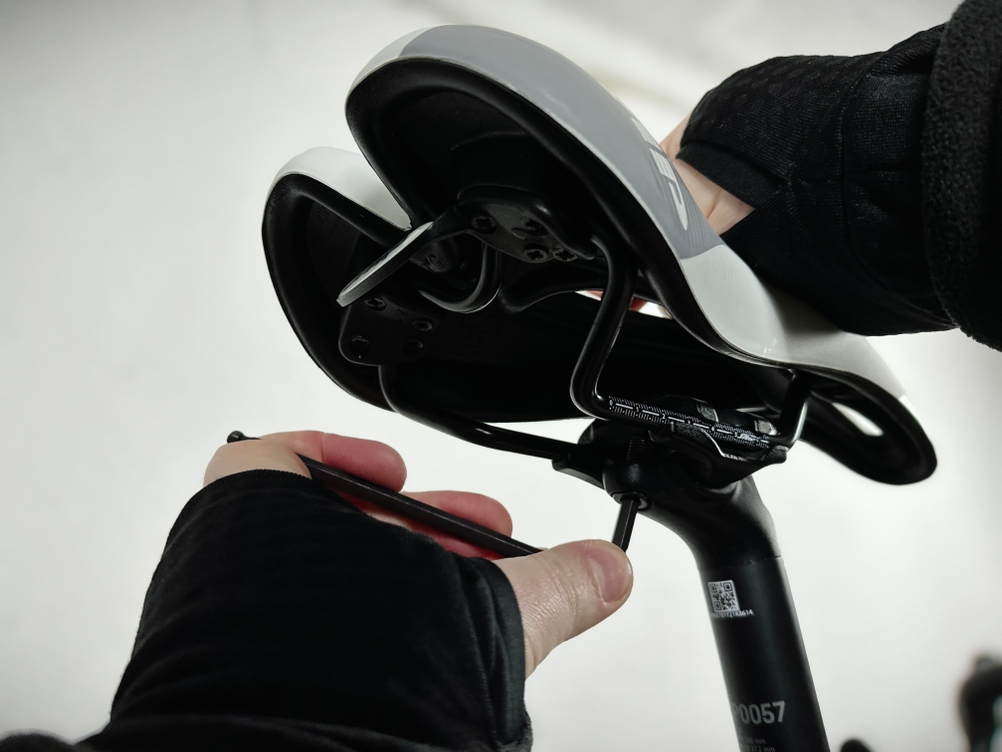 Der Selle SMP Extra Color Edition wird mit einem Inbusschlüssel an der Sattelstütze eingestellt. Zwei Hände fixieren den Sattel während der Justierung.