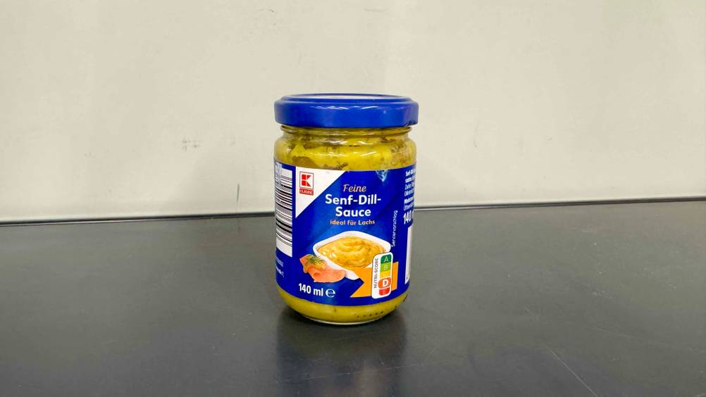 Senf-Dill-Sauce getestet: Ein Glas vor einer hellen Wand von vorne.