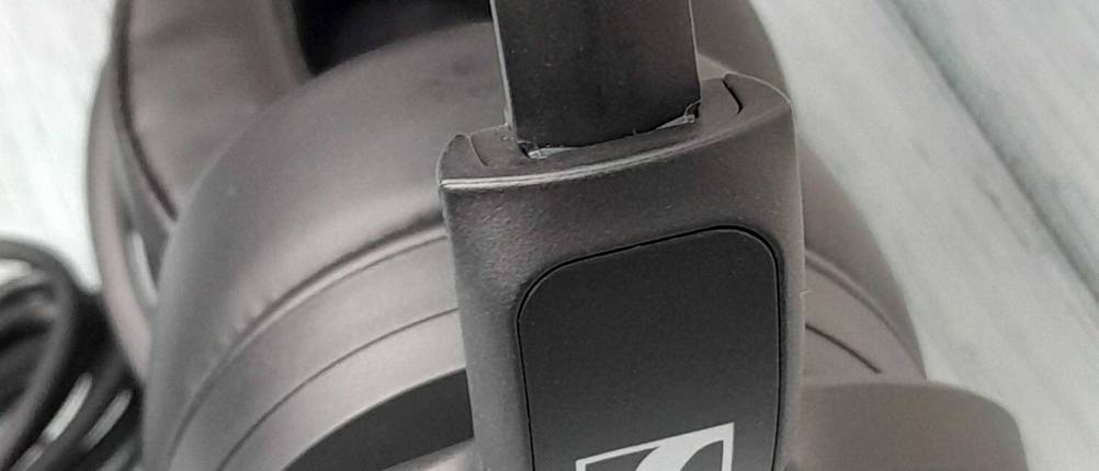 Noise-Cancelling-Kopfhörer-Test: Detailaufnahme des verstellbaren Bügels eines schwarzen Kopfhörers auf heller Fläche