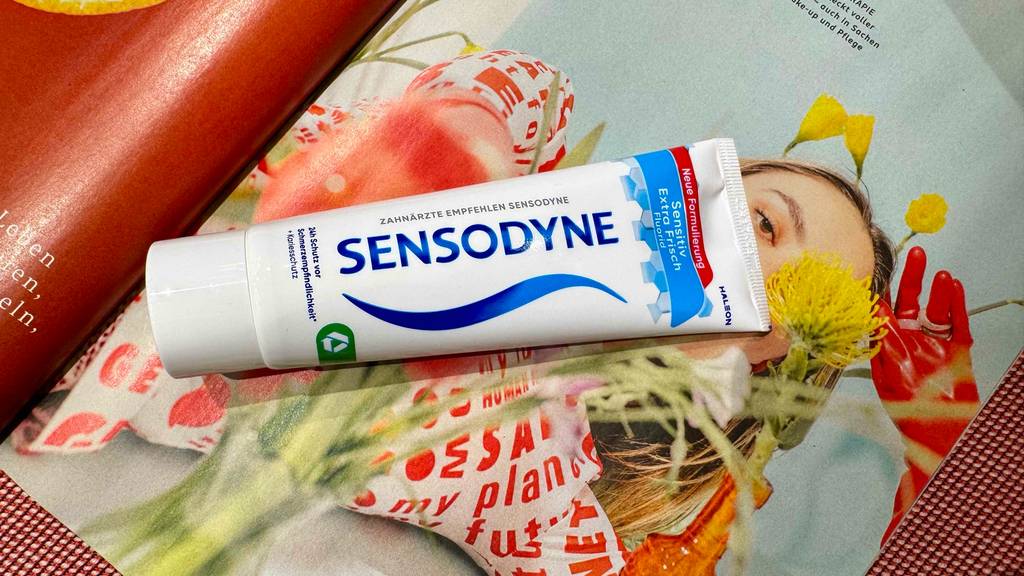Sensodyne-Zahnpasta-Test: Eine Tube liegt auf aufgeschlagenen Zeitschrift.