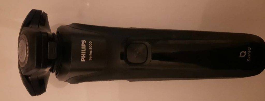 Schwarzer getesteter Philips-Rasierer Series 5000 liegt auf einem hellen Untergrund.