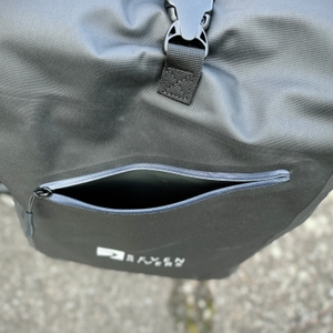 Geöffnete Fronttasche der Sevenrivers-Fahrradtasche mit sichtbarem Innenraum. Der Reißverschluss ist halb geöffnet.