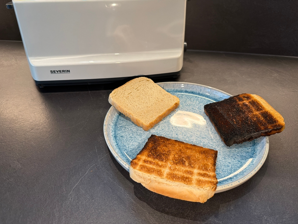 Drei unterschiedlich stark vom Severin AT 2234 getoastete Toastscheiben liegen auf einem Teller