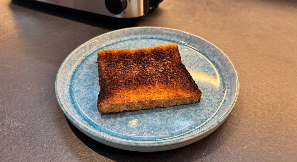 Ein dunkler Toast liegt auf einem Teller.