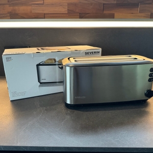 Der Severin AT 2509 steht neben seinem Karton auf einer Küchenarbeitsplatte.