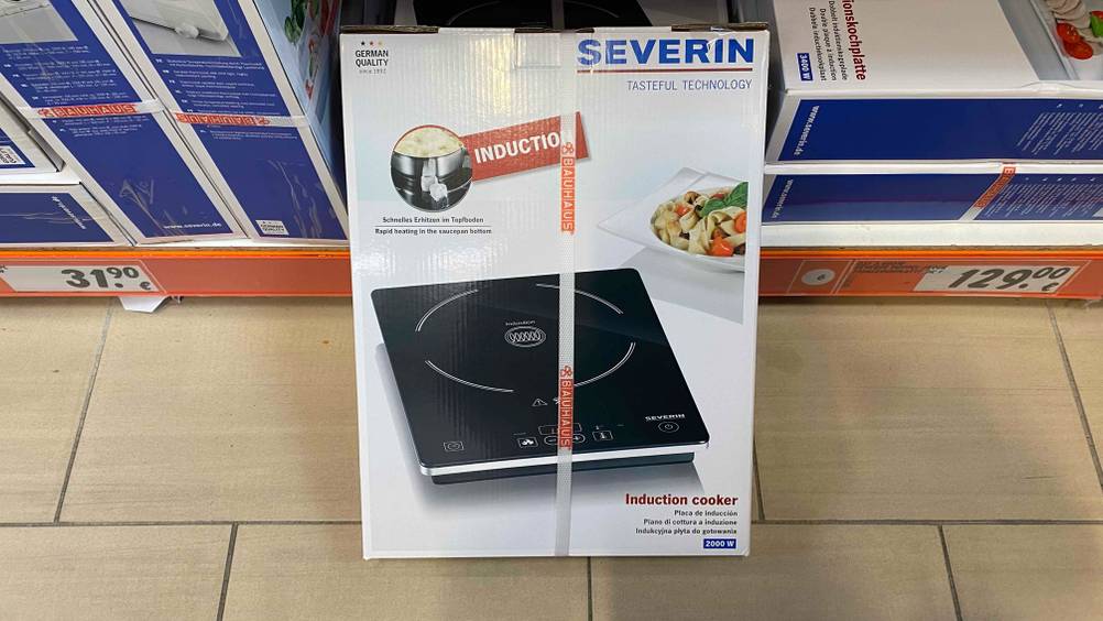 Induktionskochplatte im Test: ein verpacktes Gerät von Severin steht vor einem Regal.