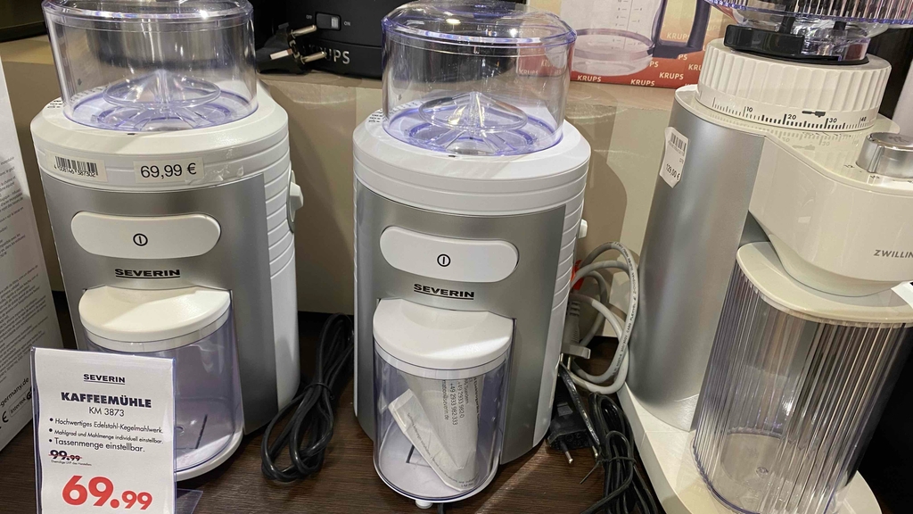 Kaffeemühle im Test: Zwei Severin Kaffeemühlen stehen nebeneinander auf einer Verkaufsfläche.