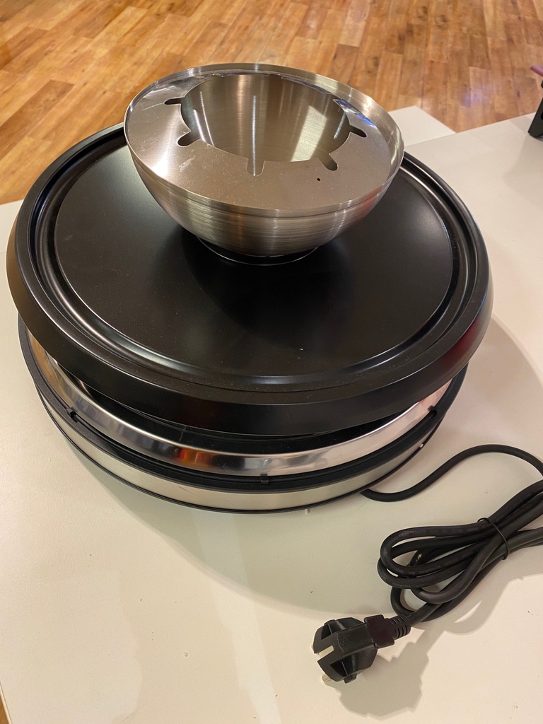 Raclette im Test: Ein Gerät auf weißer Fläche, von oben betrachtet mit einem Fondue-Aufsatz.