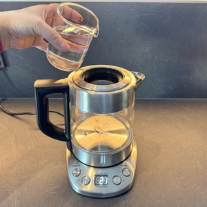 Eine Hand gießt Wasser in den Severin WK 3473.