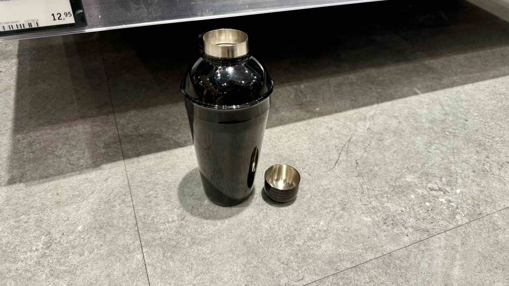 Ein getesteter Shaker von schräg oben, daneben die Verschlusskappe auf einem Fließenboden.