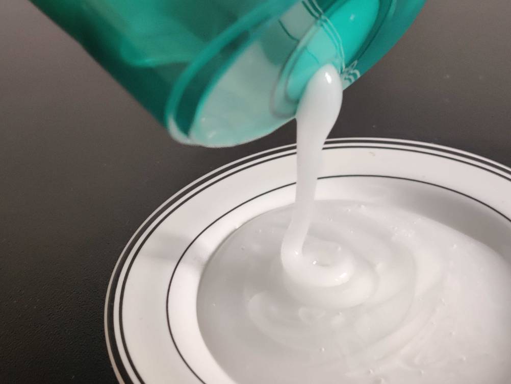 Shampoo für fettiges Haar im Test: Aus einer Flasche fließt Shampoo auf einen Teller.
