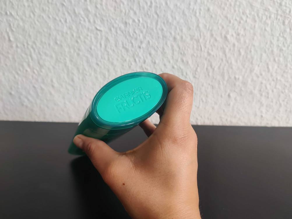 Shampoo für fettiges Haar im Test: Nahaufnahme der Verschlusskappe mit Logo von oben, von einer Hand gehalten.
