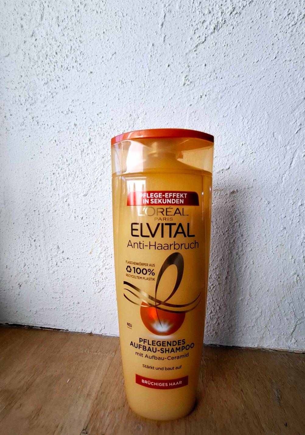 Eine Flasche Shampoo gegen Haarbruch im Test steht vor einer hellen Wand.