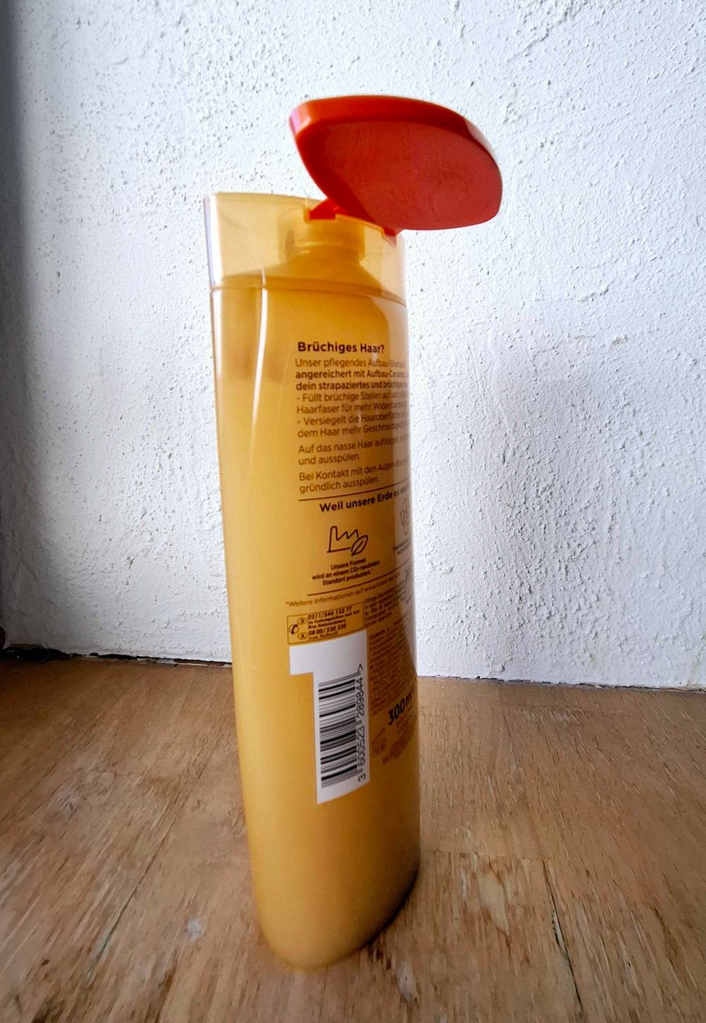 Ein Shampoo gegen Haarbruch im Test mit geöffneter Kappe von schräg seitlich.
