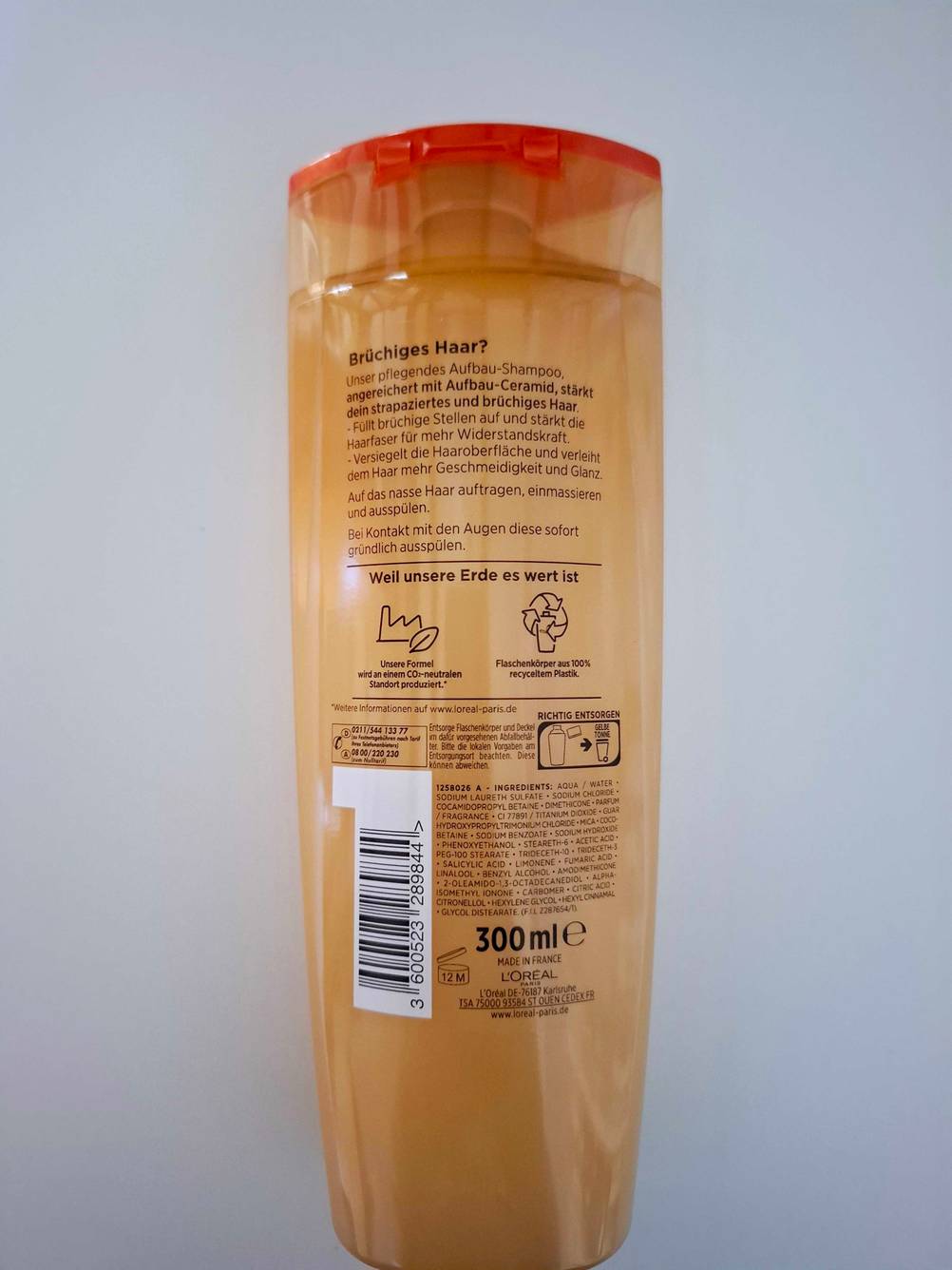 Rückseite des getesteten Shampoos gegen Haarbruch vor einer hellen Fläche.