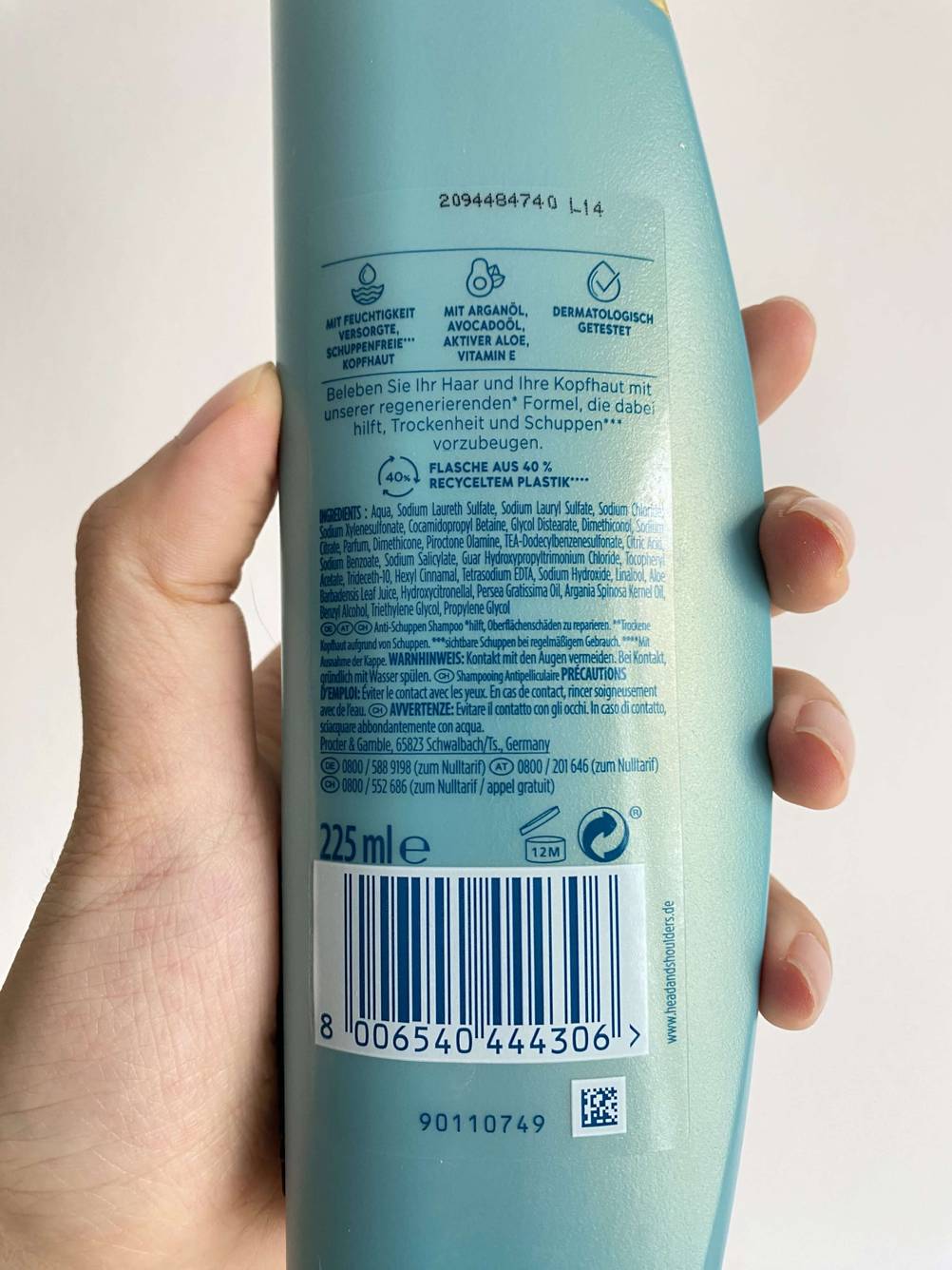 Shampoo getestet: Eine Hand hält eine Flasche mit der Rückseite nach vorne.