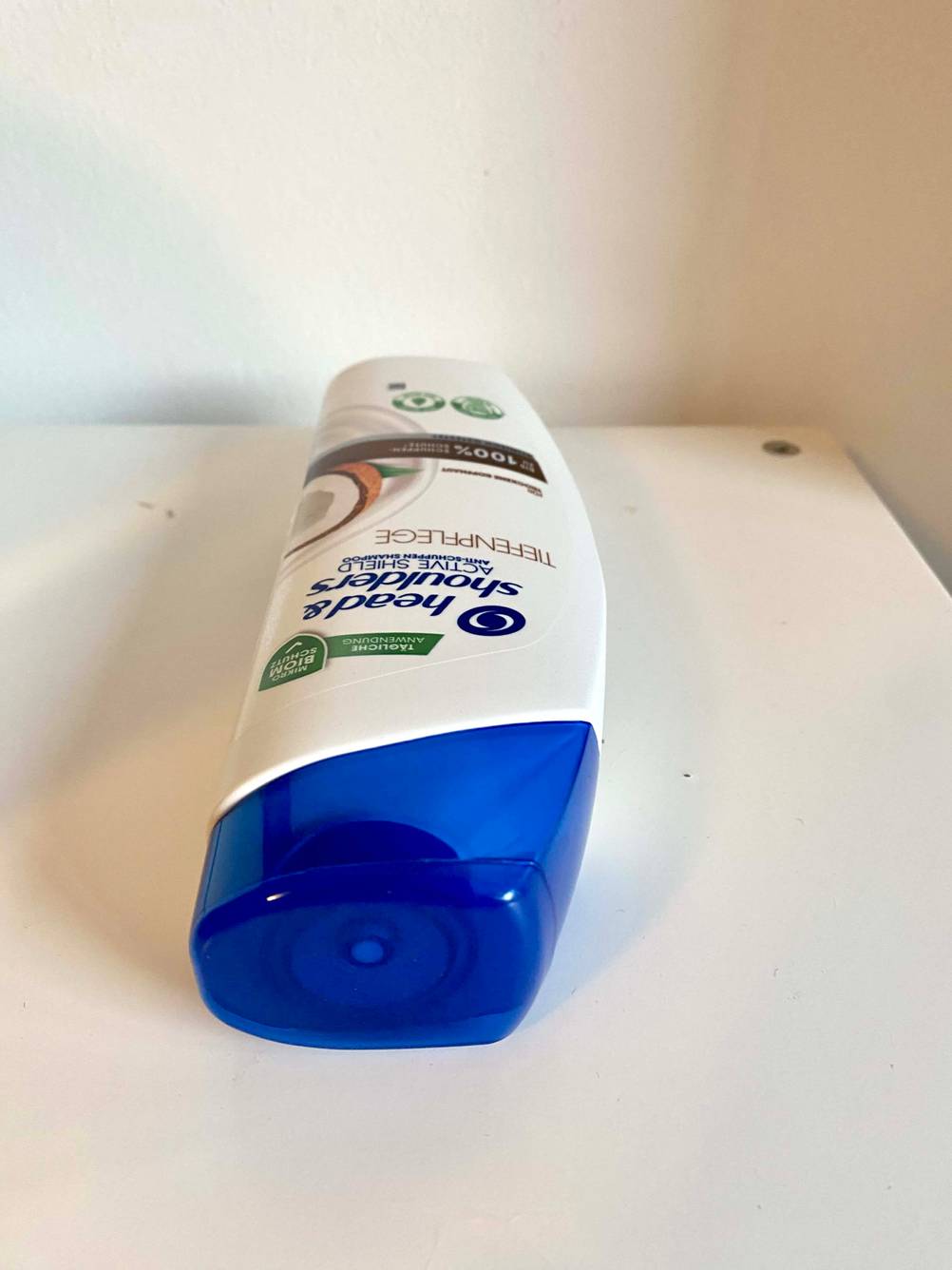 Nahaufnahme der Verschlusskappe einer liegenden Flasche des getesteten Shampoos gegen Schuppenflechte.