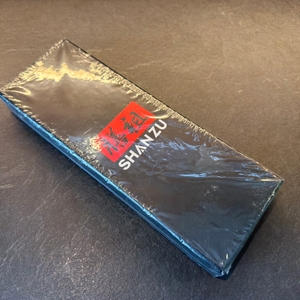 Der eingeschweißte Karton vom Shan-Zu-Gemüsemesser liegt auf einem Tisch