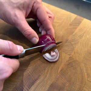 Eine Zwiebel wird mit dem Shan-Zu-Gemüsemesser geschnitten