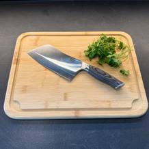 Das Shan-Zu-Hackmesser liegt neben Petersilie auf einem Holzbrett