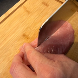 Ein Stück Fleisch wird mit dem Shan-Zu-Hackmesser geschnitten