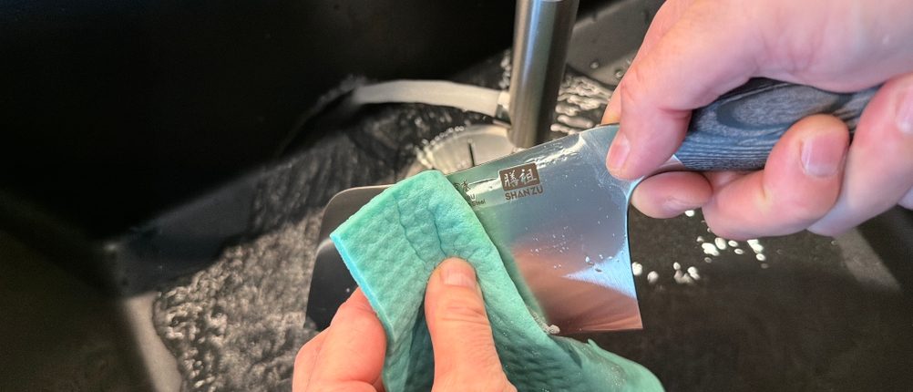 Mit einem Lappen wird das Shan-Zu-Hackmesser gereinigt