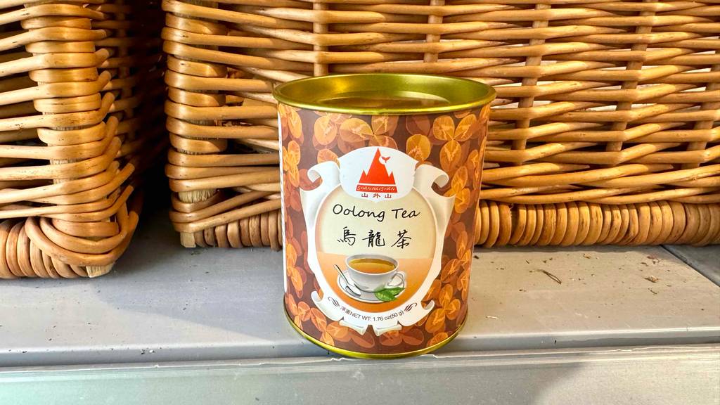 Eine Dose getesteter Oolong-Tee steht vor einem Korb.