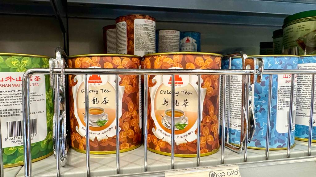 Oolong-Tee im Test: Mehrere Dosen stehen neben- und hintereinander zwischen anderen Dosen-Produkten in einem Regal.