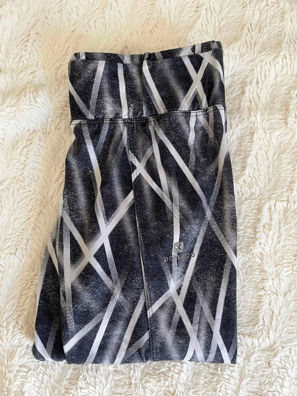 Eine getestete Shape-Leggings zusammengefaltet mit Bund auf einer hellen Fläche.