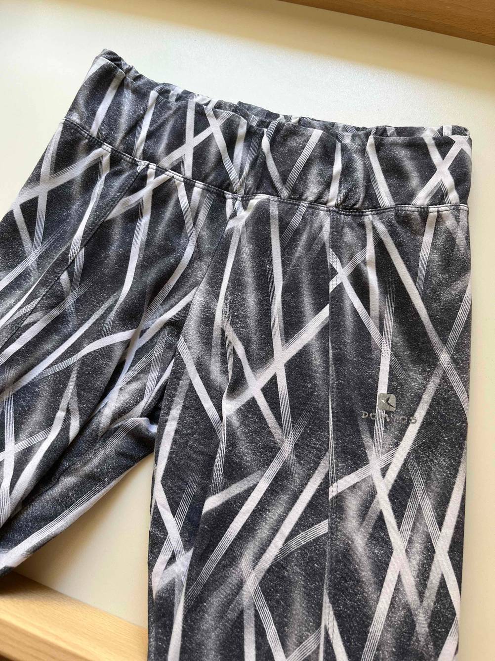 Shape-Leggings getestet: Bund einer Leggins von vorne mit Logo auf einer hellen Fläche.